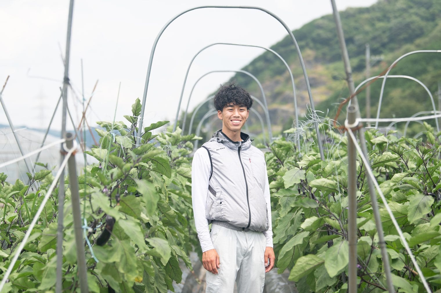 ナス畑で笑顔を見せる金﨑心哉さん